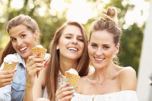 heureux groupe d'amis mangeant des glaces à l'extérieur photo