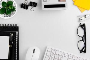 vue de dessus du bureau blanc moderne avec clavier d'ordinateur, page de cahier vierge et autres équipements sur fond blanc. concept d'espace de travail, style de gestion de l'espace de travail, espace de conception d'entreprise avec copie photo