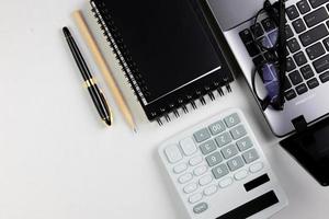 vue de dessus du bureau blanc moderne avec clavier d'ordinateur, page de cahier vierge et autres équipements sur fond blanc. concept d'espace de travail, style de gestion de l'espace de travail, espace de conception d'entreprise avec copie photo