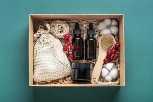 ensemble pour boîte de soins bouteilles d'huile et de crème cosmétiques écologiques, brosse pour le lavage, tampons de coton sur fond vert cadeau pour petite amie, mère pour célébrer le concept de noël vue de dessus à plat photo