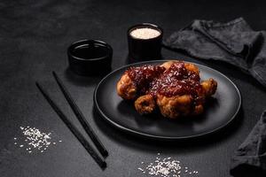 savoureuses cuisses de poulet épicées avec sauce teriyaki et graines de sésame photo