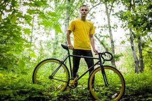 un jeune homme s'est arrêté pour se reposer avec son vélo dans un parc public. photo