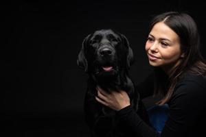 une fille tient un chien labrador retriever dans ses bras. photo