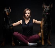 portrait d'un chien doberman et d'un chien de berger belge avec une fille propriétaire. photo