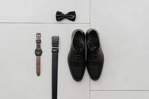 présentation détaillée d'une montre homme, d'une paire de chaussures homme, de cravates et d'une ceinture, bon pour le matériel marketing. photo
