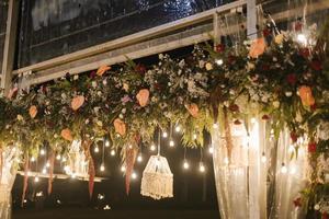belle combinaison de détails de décoration florale la nuit à la réception de mariage. photo