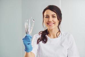 portrait d'une dentiste professionnelle avec un équipement qui se tient à l'intérieur photo