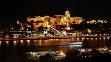 photo de nuit, photographie longue exposition, célèbre château de buda historique illuminé la nuit, vue sur le palais royal au bord du danube, budapest, hongrie