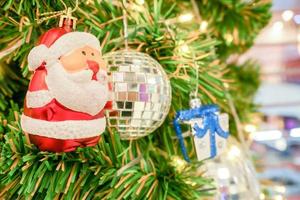 gros plan du père noël, boule de cristal avec une boîte-cadeau et des lumières de noël décorées sur un pin le jour de noël. photo