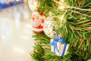 père noël, boule de cristal avec une boîte-cadeau et des lumières de noël décorées sur un pin le jour de noël. photo