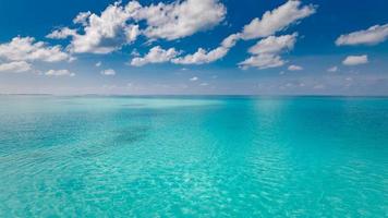 mer et ciel. eau de mer bleue parfaite et ciel bleu avec nuages blancs moelleux, paysage marin de plage tropicale et vue sur la mer. fond horizontal de la mer bleue. vue panoramique photo