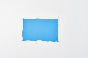 feuille de bord déchiré papier bleu déchiré sur un fond blanc. photo