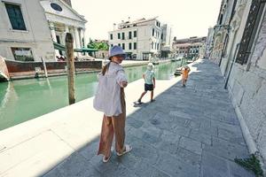 enfants marchant près du canal à venise, italie. photo