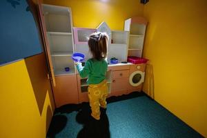 petite fille jouant à l'aire de jeux de cuisine intérieure pour enfants. photo