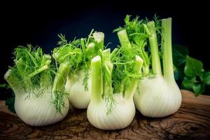 bulbes de fenouil vert et blanc sur bois d'olivier photo