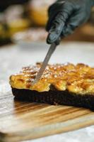 gâteau au caramel coupé par le chef sur une planche à découper en bois, dessert délicieux, dessert pour une tasse de café, boulangerie maison photo