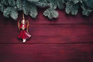 décoration d'ange de noël sur des brindilles de sapin, fond de veille de vacances photo