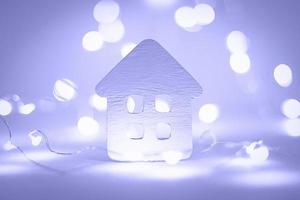 maison en papier avec guirlande de noël lumières violettes, vacances d'hiver, ambiance hivernale photo