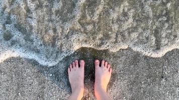 pied sur la plage avec vague de la mer photo