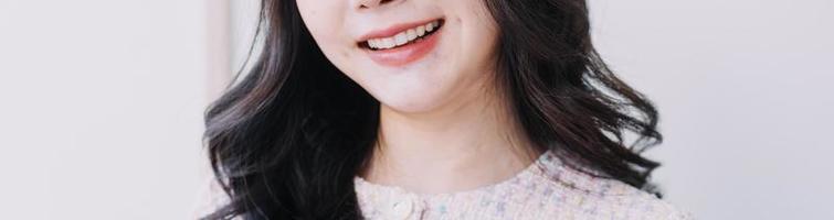 concept de stomatologie, portrait partiel d'une fille avec de fortes dents blanches regardant la caméra et souriant, les doigts près du visage. gros plan sur une jeune femme chez le dentiste, en studio, à l'intérieur photo