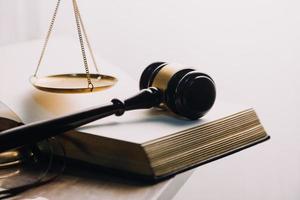 concept de justice et de droit. juge masculin dans une salle d'audience avec le marteau, travaillant avec, clavier d'ordinateur et d'accueil, lunettes, sur table à la lumière du matin photo