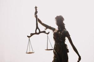 concept de justice et de droit. juge masculin dans une salle d'audience avec le marteau, travaillant avec, clavier d'ordinateur et d'accueil, lunettes, sur table à la lumière du matin photo