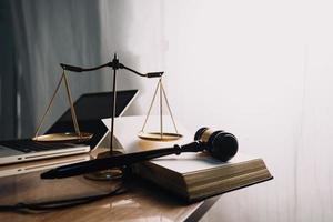 concept de justice et de droit. juge masculin dans une salle d'audience avec le marteau, travaillant avec, clavier d'ordinateur et d'accueil, lunettes, sur table à la lumière du matin photo