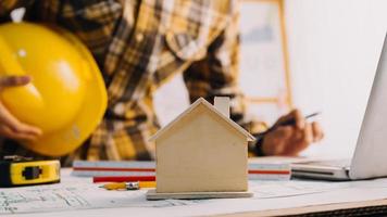 Deux collègues discutant des données de travail et tablette, ordinateur portable avec sur le projet architectural sur le chantier de construction au bureau au bureau photo