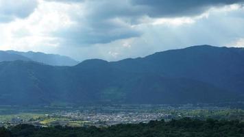 la vue sur le champ de riz jaune de récolte situé dans la vallée parmi les montagnes avec le ciel nuageux en arrière-plan photo