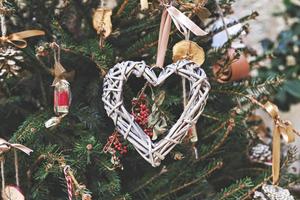 arbre de noël décoré d'une couronne tissée en forme de coeur et d'autres ornements de noël zéro déchet faits à la main photo