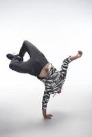 cool jeune break dancer effectuant en studio sur fond blanc. photo