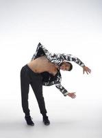 cool jeune break dancer effectuant en studio sur fond blanc. photo