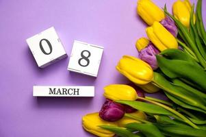 Notion du 8 mars. tulipes colorées sur violet pastel. journée internationale de la femme photo