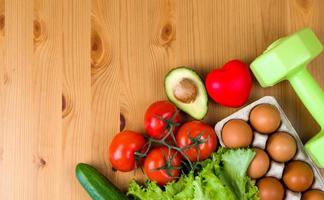 mise à plat de produit sain près du coeur et des haltères. régime et détox. Habitudes alimentaires saines. style de vie sportif. séances d'entraînement photo