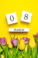 carte verticale avec concept du 8 mars. tulipes colorées sur violet jaune. journée internationale de la femme photo