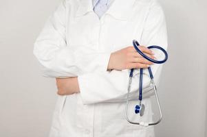 un médecin en blouse blanche tient un stéthoscope dans ses mains. concept de soins de santé. photo