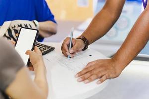 homme d'affaires remplissant le formulaire d'accord de document d'investissement de contrat avec le client. photo