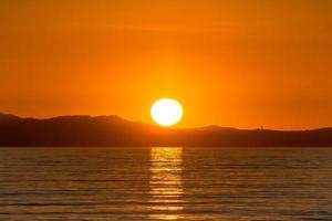 vue panoramique sur le globe solaire reflété dans la mer méditerranée au coucher du soleil doré dans le sud de la france photo