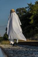 fantôme à la campagne profitant du soleil et du train qui passe derrière, des voies ferrées photo