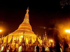 les pagodes dorées et les mondops sont illuminés à la lumière de la nuit photo