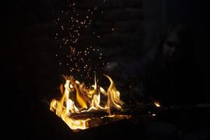flammes de bûcher. feu dans l'obscurité. brûler du bois de chauffage. photo