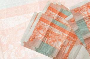 3 billets convertibles en pesos cubains sont empilés sur fond de gros billets semi-transparents. présentation abstraite de la monnaie nationale photo