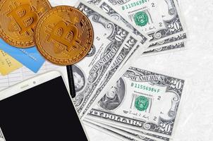 Billets de 20 dollars américains et bitcoins dorés avec smartphone et cartes de crédit. concept d'investissement en crypto-monnaie. minage ou commerce de crypto photo