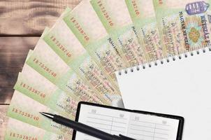 Éventail et bloc-notes de 200 forints hongrois avec carnet de contacts et stylo noir. concept de planification financière et de stratégie d'entreprise photo