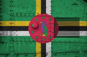drapeau de la dominique représenté sur la partie latérale d'un gros plan de char blindé militaire. arrière-plan conceptuel des forces armées photo