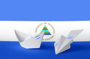 drapeau du nicaragua représenté sur un avion et un bateau en papier origami. concept d'art fait à la main photo