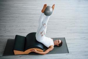 pour les jambes. jeune femme sportive confiante avec un type de corps mince dans le centre sain faisant des exercices en utilisant un équipement spécial photo