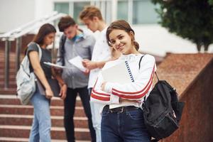 jolie adolescente. groupe de jeunes étudiants en vêtements décontractés près de l'université pendant la journée photo