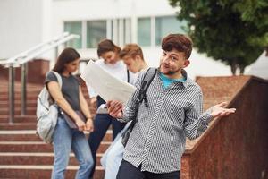 gars positif. groupe de jeunes étudiants en vêtements décontractés près de l'université pendant la journée photo