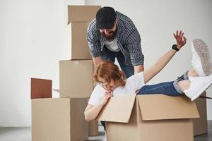 la fille est à l'intérieur de la boîte. couple heureux ensemble dans leur nouvelle maison. conception du déménagement photo